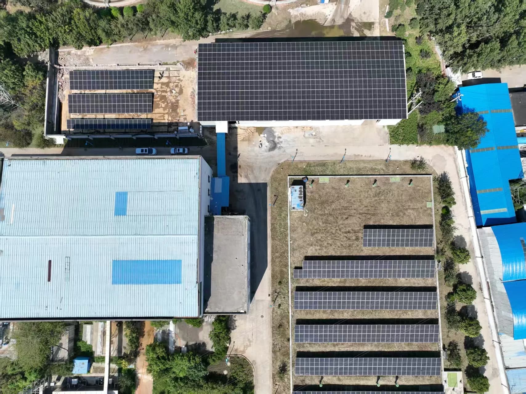 Aerial view of photovoltaic arrays installed across industrial rooftops.