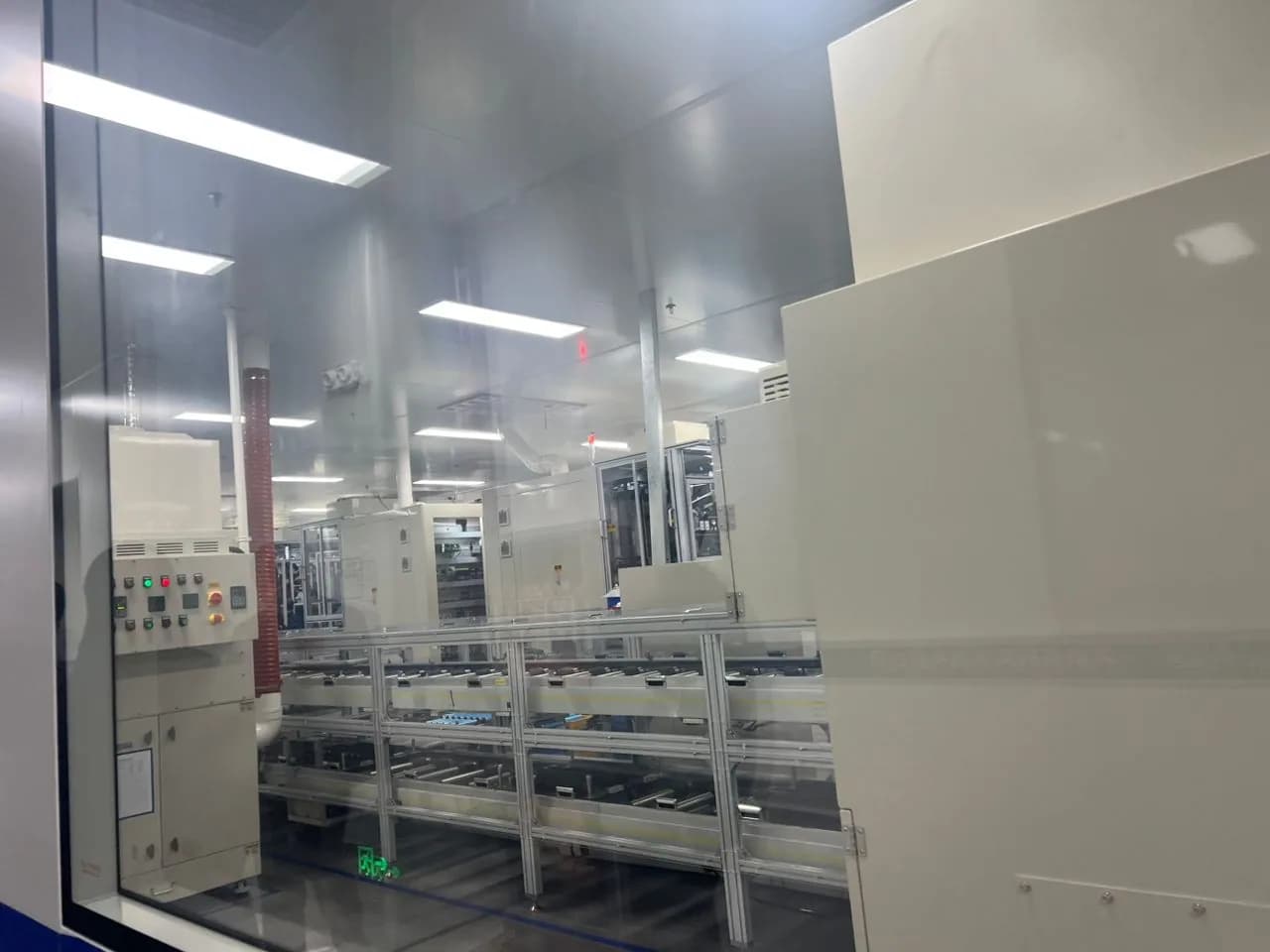 Automated conveyor equipment inside a clean battery production facility.