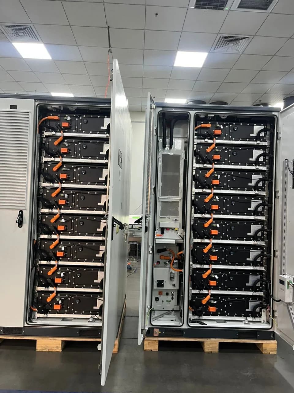 Battery modules and high-voltage connections inside a commercial energy storage cabinet.