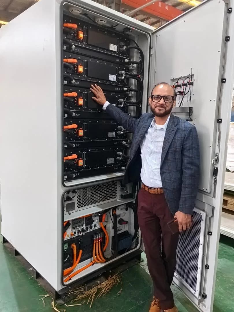 Partner inspecting battery modules inside an energy storage cabinet.