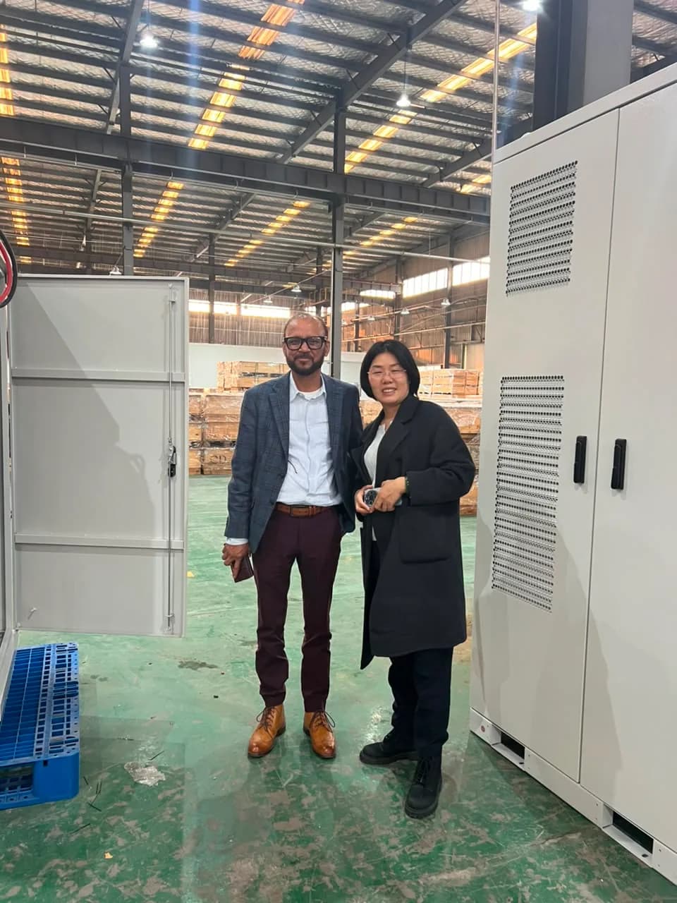 Rongkai Solar representative accompanying a partner during an energy storage factory visit.