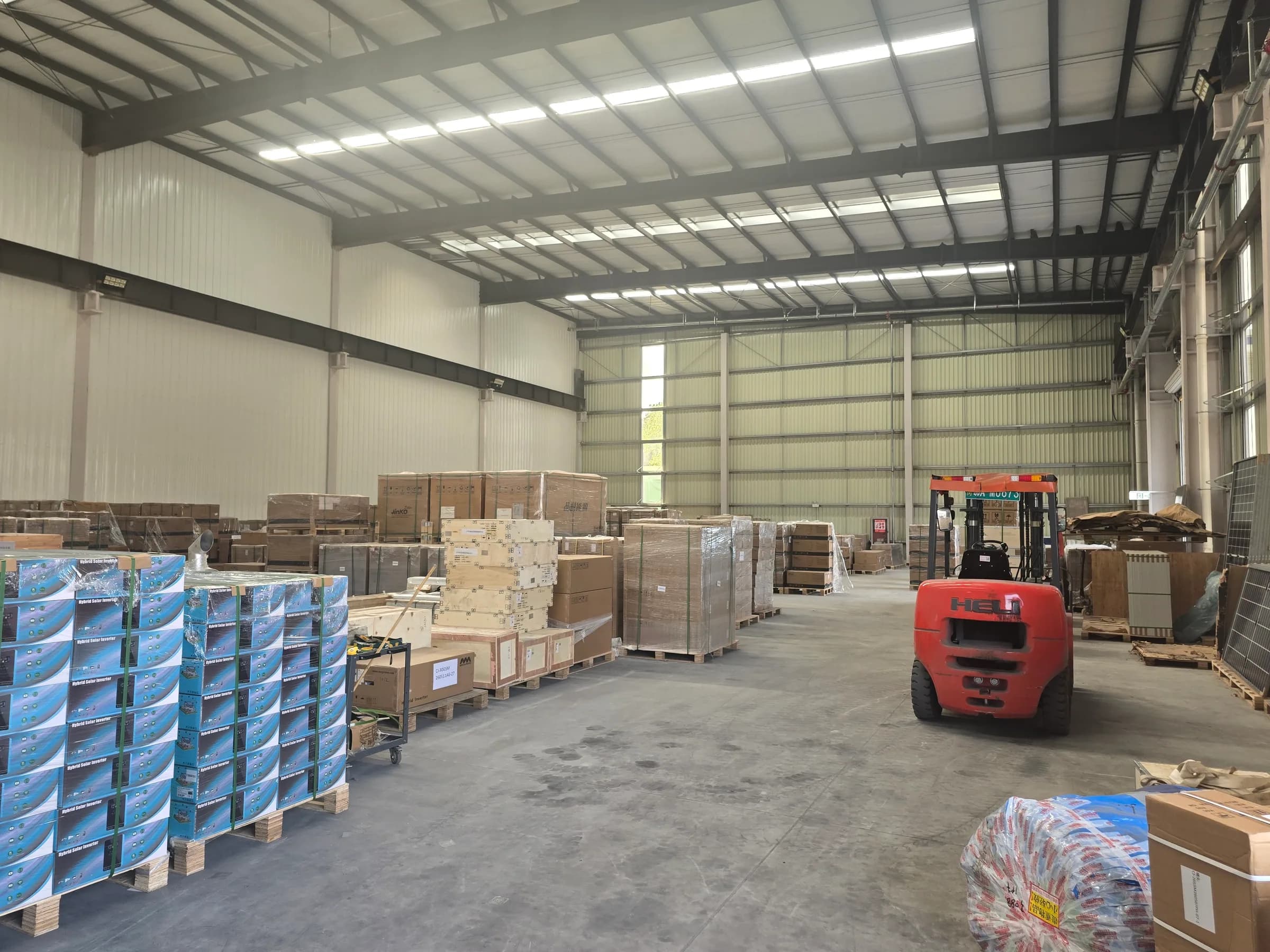 Palletized solar equipment and a forklift inside the Rongkai Solar export warehouse.