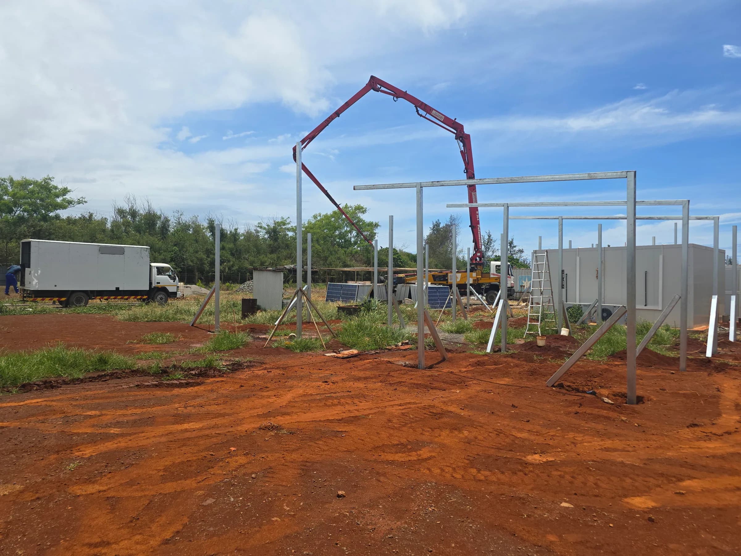 Site worker beside steel framing under construction for a solar project.