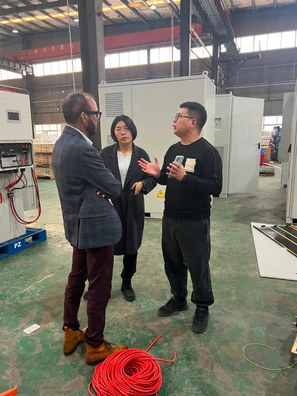 Rongkai Solar representatives discussing battery production equipment with partners.